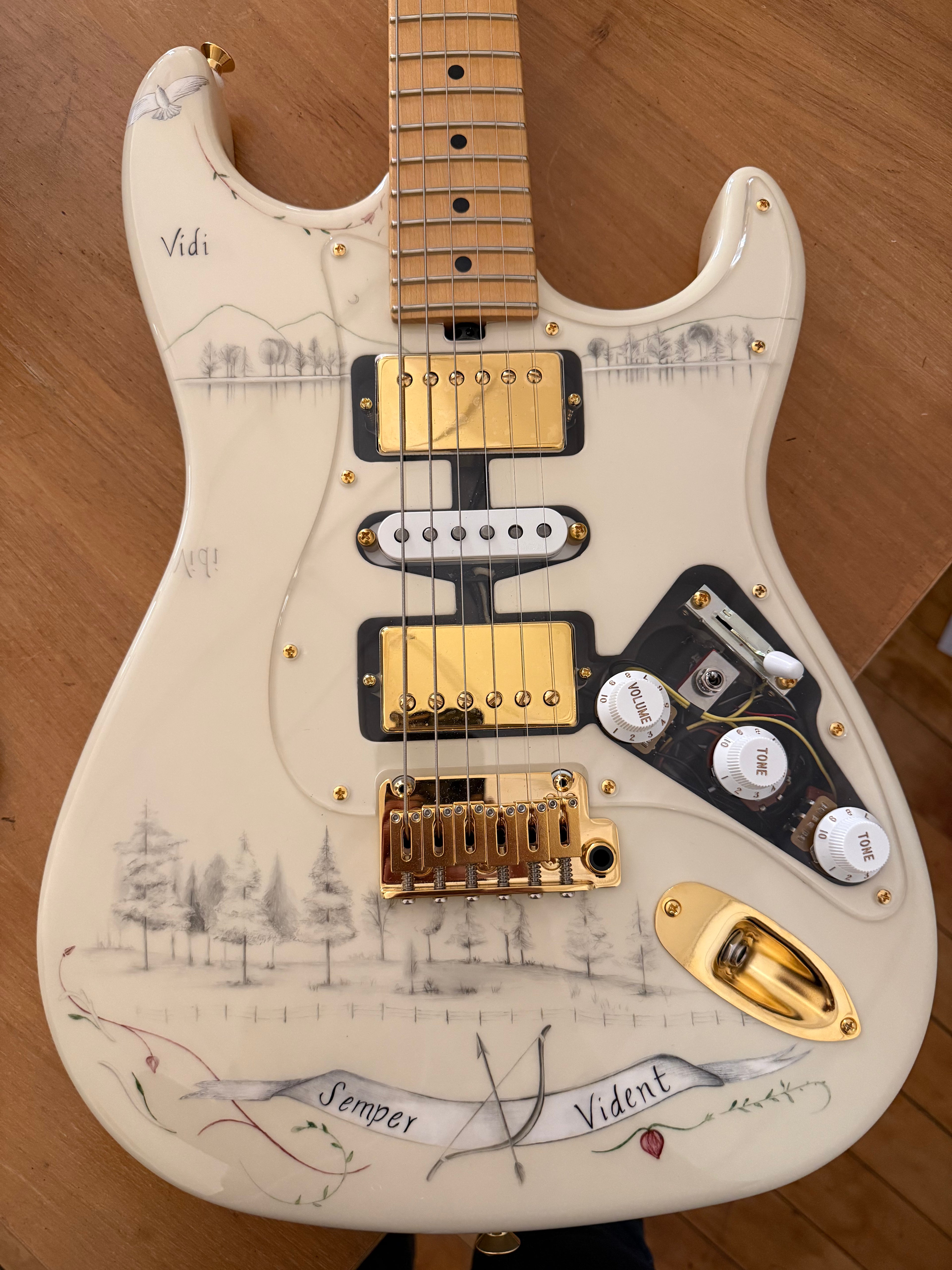 A cream electric guitar body with an ornate pencil design on its surface 