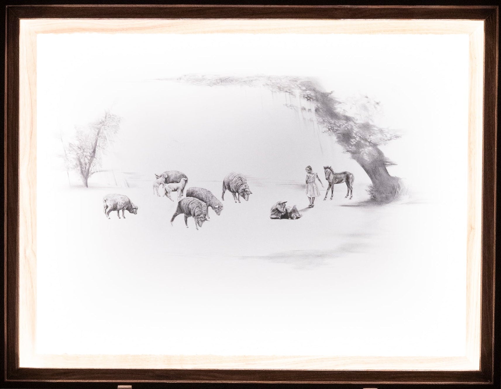 Framed black and white drawing of girl and animals in a dreamy landscape